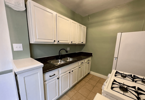 a kitchen with white cabinets and a stove and a sink